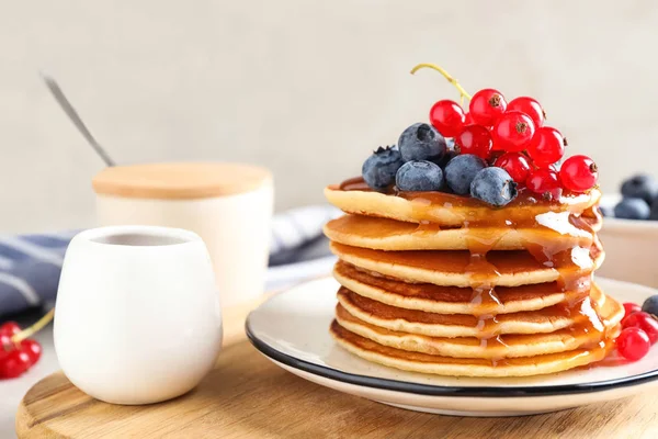 Pancake lezat dengan buah beri segar dan sirup di atas meja — Stok Foto