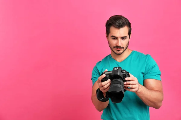 Joven fotógrafo con cámara profesional sobre fondo rosa. Espacio para texto —  Fotos de Stock