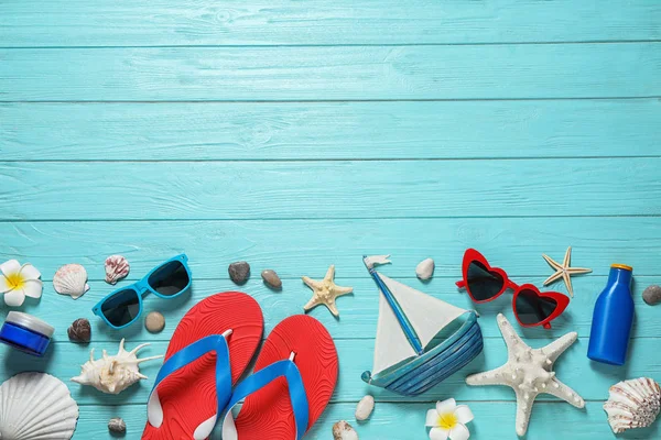Açık mavi ahşap arka plan üzerinde şık plaj aksesuarları ile Düz döşeme kompozisyon, metin için alan