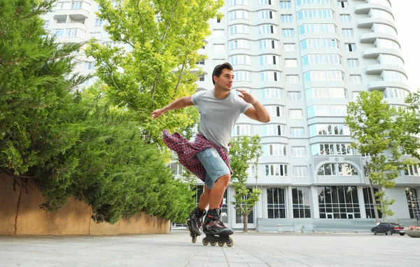 Knappe jonge man roller schaatsen buitenshuis. Recreatieve activiteit — Stockfoto