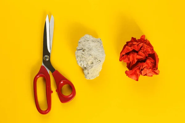 Composición plana con piedra, papel y tijeras sobre fondo amarillo —  Fotos de Stock