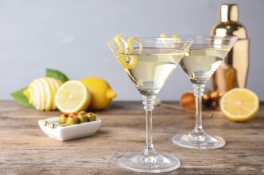 Gri arka plan karşı ahşap masada lezzet ile limon damla martini kokteyl Gözlük