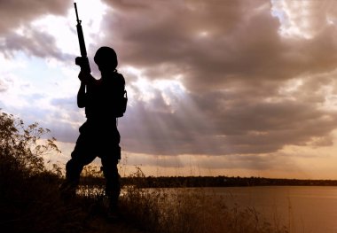 Dışarıda devriye gezen makineli tüfekli bir asker. Askerlik hizmeti