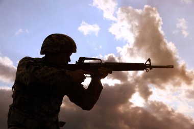 Dışarıda devriye gezen makineli tüfekli bir asker. Askerlik hizmeti