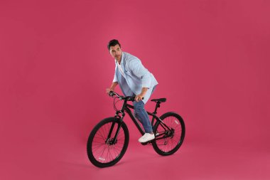 Pembe arka plan üzerinde modern bisiklet ile Yakışıklı genç adam