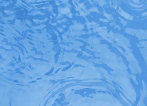 Концентрические волны на голубой поверхности воды после падения капель, вид сверху — стоковое фото