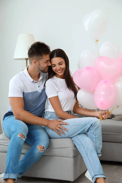 Junges Paar mit Luftballons zu Hause. Feier zum Valentinstag — Stockfoto