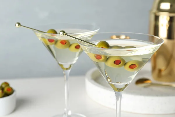Glas klassiska Dry Martini med Oliver på bordet mot grå bakgrund — Stockfoto