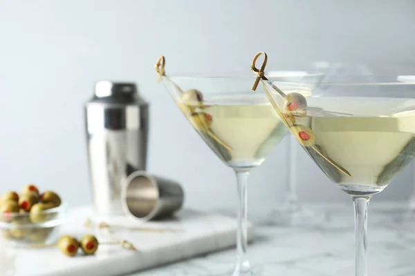 Glas klassisk Dry Martini med Oliver på vit marmorbord mot grå bakgrund — Stockfoto