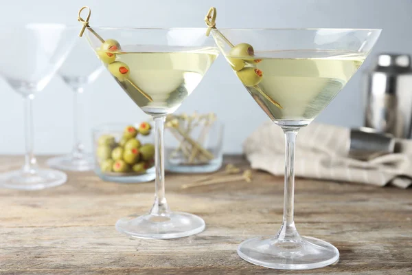 Bicchieri di Martini Secco Classico con olive su tavolo in legno su fondo grigio — Foto Stock