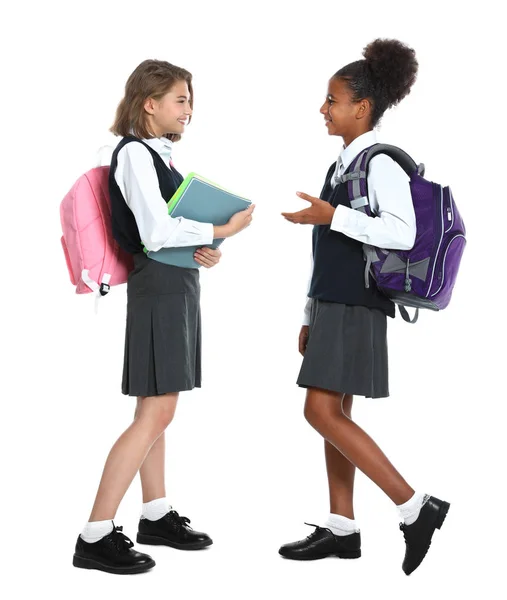 Meninas felizes em uniforme escolar no fundo branco — Fotografia de Stock