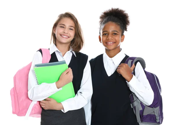 Счастливые девочки в школьной форме на белом фоне — стоковое фото