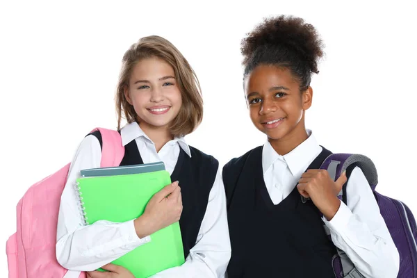 Meninas felizes em uniforme escolar no fundo branco — Fotografia de Stock