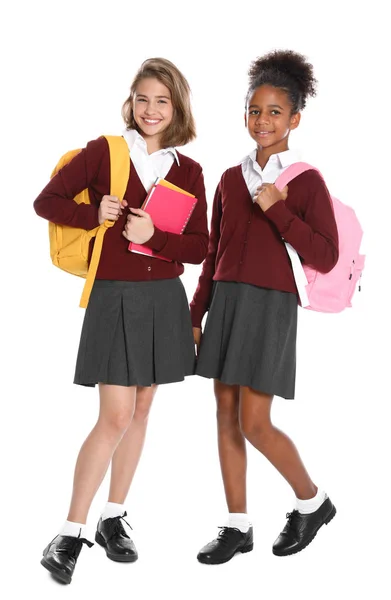 Meninas felizes em uniforme escolar no fundo branco — Fotografia de Stock