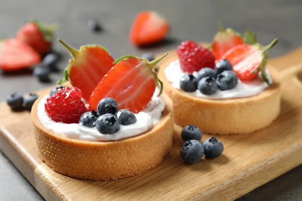 Produse de patiserie dulci delicioase cu fructe de padure pe masa gri, closeup — Fotografie, imagine de stoc