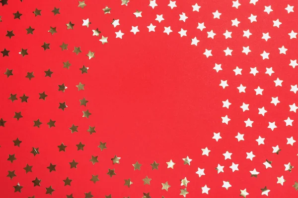 Konfettisz csillagok kerete a térben a szöveg piros háttér, felülnézet. Karácsonyi ünnepély — Stock Fotó