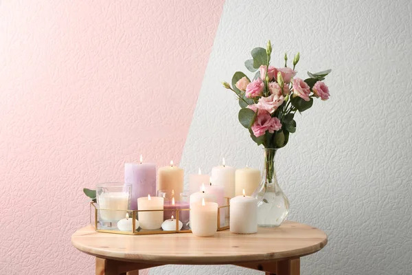 Composição com velas acesas na mesa contra fundo de cor — Fotografia de Stock
