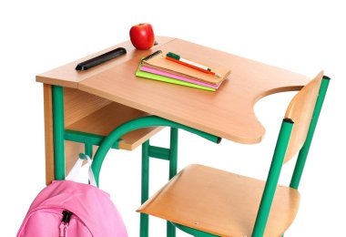 Beyaz arka planda kırtasiye, sırt çantası ve elma ile ahşap okul sırası