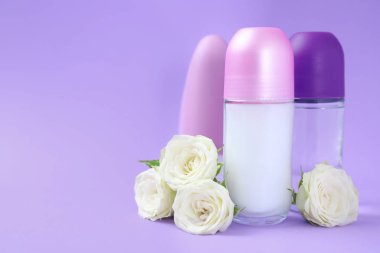 Mor arka plan üzerinde farklı kadın roll-on deodorantlar ile kompozisyon, metin için alan
