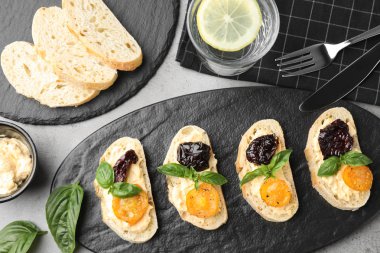 Gri masada lezzetli taze domates bruschettas, düz yatıyordu
