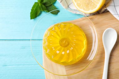 Açık mavi ahşap masa üzerinde lezzetli sarı jöle, düz yatıyordu