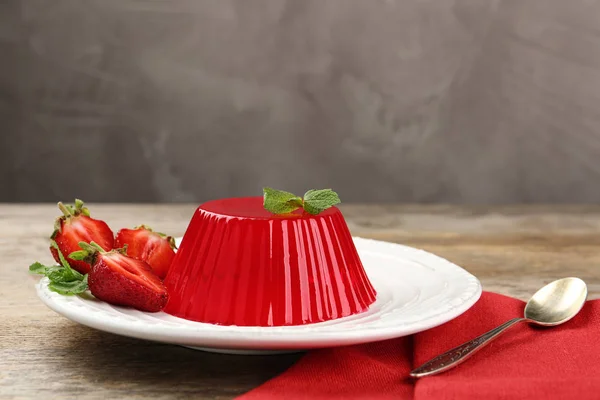 Tallrik med smakrik jordgubbs gelé serverad på träbord, plats för text — Stockfoto