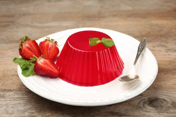 Assiette de savoureuse gelée de fraises servie sur table en bois — Photo