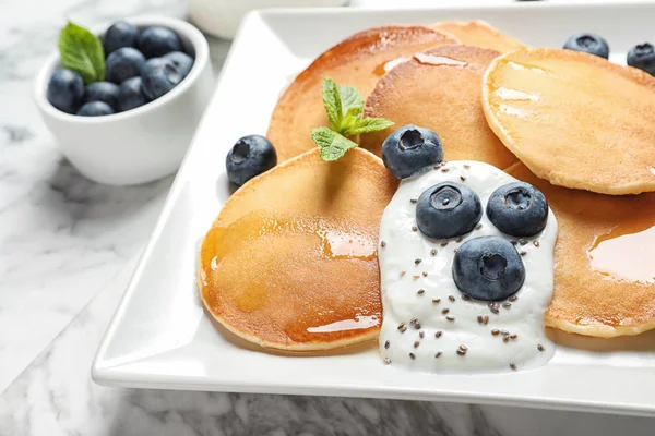 Piring pancake lezat dengan blueberry, saus dan mint di atas meja marmer, closeup — Stok Foto