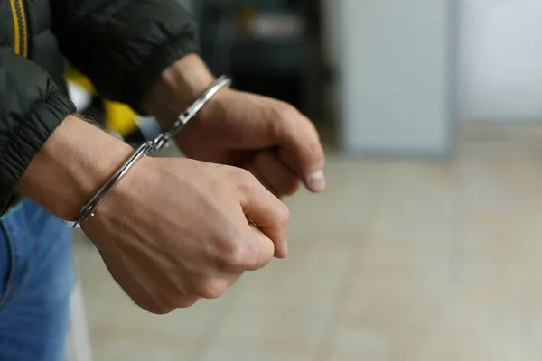 Man detained in handcuffs indoors, space for text. Criminal law — Stock Photo, Image