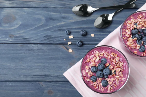 Flache Liegekomposition mit köstlichem Blaubeer-Smoothie auf blauem Holzhintergrund. Raum für Text — Stockfoto