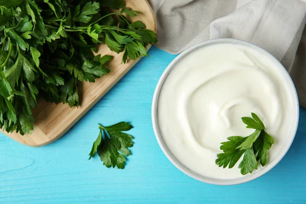 Flat lay composition with sour cream and parsley on light blue wooden table — Stock Photo, Image