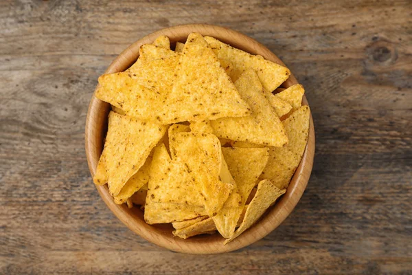 Bowl with tasty Mexican nachos chips on wooden table, top view — Stock Photo, Image