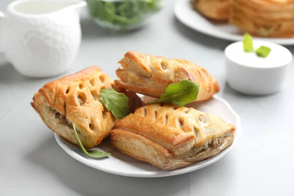 Frisches köstliches Blätterteiggebäck auf hellem Tisch serviert — Stockfoto