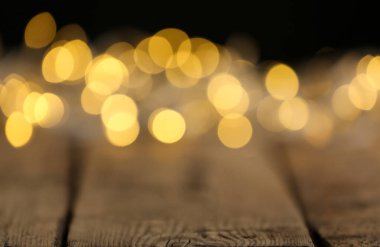 Ahşap masa üzerinde Sarı Noel ışıkları, bulanık görünüm