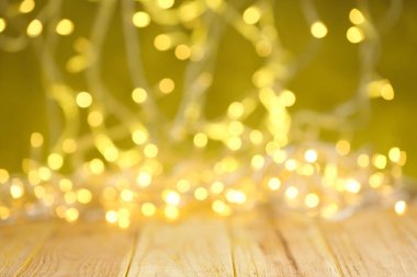 Ahşap masa üzerinde Sarı Noel ışıkları, bulanık görünüm