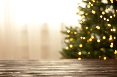 Arka planda sarı Noel ışıkları ile boş masa ve bulanık köknar ağacı, bokeh etkisi. Tasarım alanı