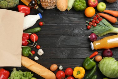 Çerçeve siyah ahşap arka plan üzerinde devrik kağıt torba ve bakkaliye ile yapılan, üst görünümü. Metin için alan