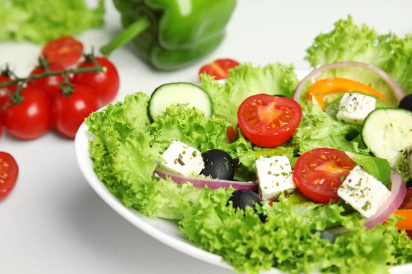 Salada grega fresca saborosa na mesa branca, close-up — Fotografia de Stock