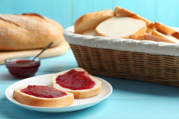 Pão fresco saboroso com geléia na mesa de madeira azul clara — Fotografia de Stock