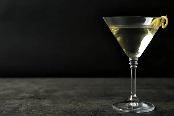 Verre de cocktail martini goutte de citron avec zeste sur table en pierre sur fond noir. Espace pour le texte — Photo