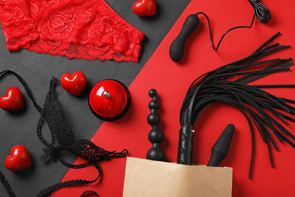 Renkli arka plan üzerinde farklı seks oyuncakları ile Kağıt alışveriş çantası, düz yatıyordu