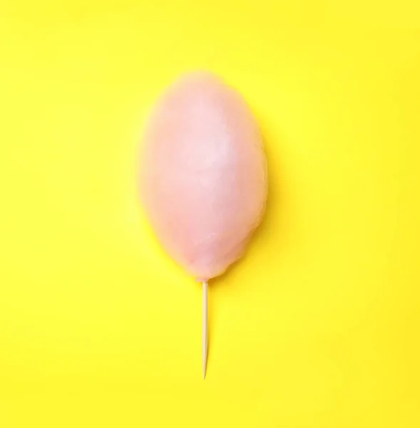 Dolce zucchero filato rosa su sfondo giallo, vista dall'alto — Foto Stock