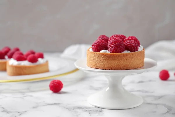 Suporte de bolo com torta de framboesa na mesa de mármore contra fundo claro. Deliciosos doces — Fotografia de Stock