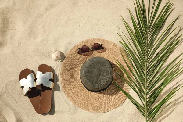 Composition à plat avec accessoires de plage élégants sur sable — Photo