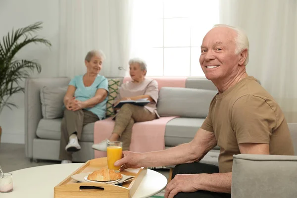 Пожилой мужчина завтракает в доме престарелых, место для смс. Помощь пожилым людям — стоковое фото