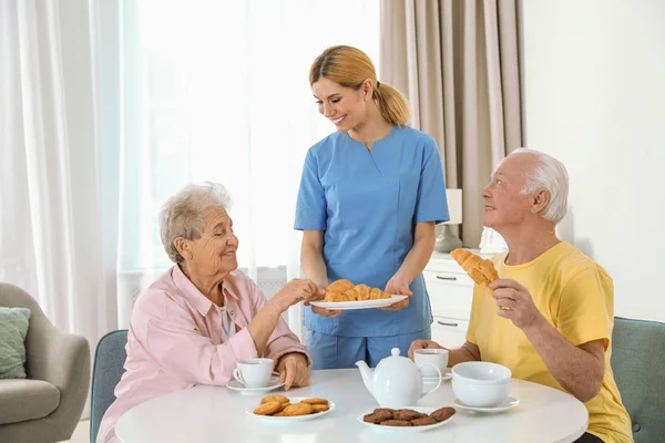 Infirmière aidant pendant le petit déjeuner des personnes âgées à la maison de retraite — Photo