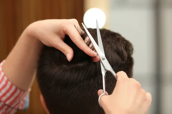 Barbeiro fazendo corte de cabelo elegante com tesoura profissional no salão de beleza, close-up — Fotografia de Stock