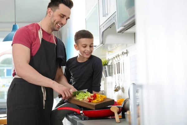Dad and son cooking together in kitchen