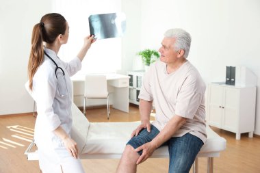 Röntgeni olan genç doktor ve klinikte kıdemli hasta. Diz problemi