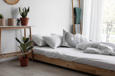 Konforlu yatak ve ev bitkileri ile şık ev iç